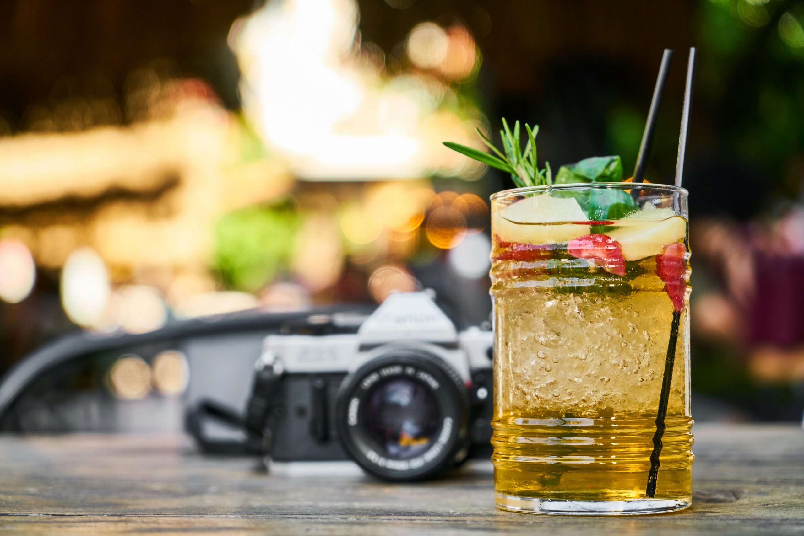 Chill out with a refreshing cocktail next to a vintage camera, perfect for summer vibes.